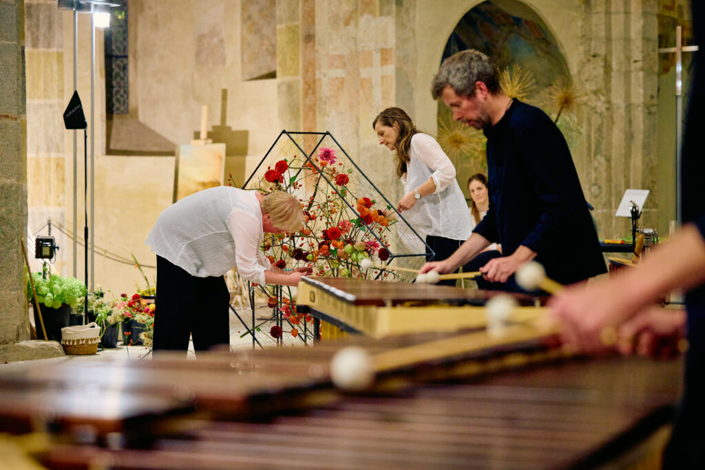 Beatrix Chopard à gauche et Nadia Joye Dafflon réalisent une composition florale en direct dans l’Abbatiale de Payerne lors de De Vert et d’Art 2024
